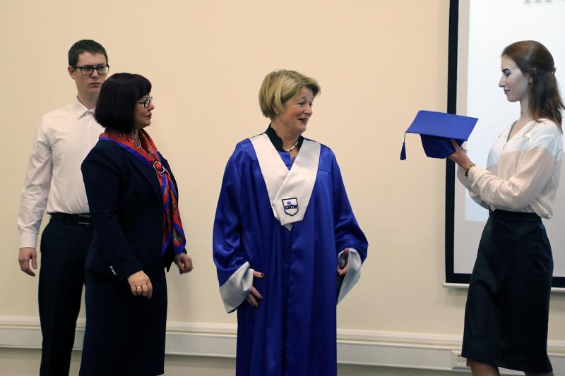 Anne får lue.jpg Anne Husebekk under seremonien ved Northern Arctic Federal University, sammen med universitetets rektor Elena Kudryashova.